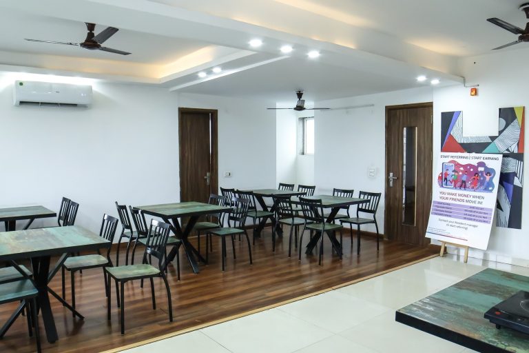 A bright and airy dining space with tables, chairs and air conditioning
