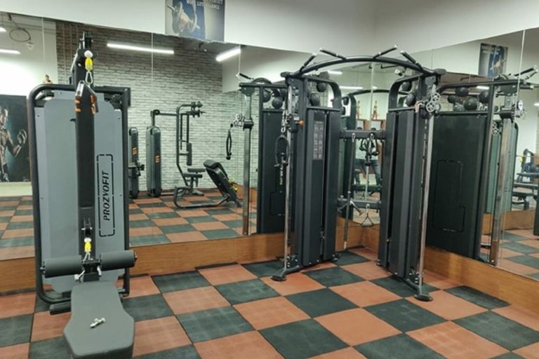 A well-equipped gymnasium with a variety of weight machines and mirrored studio walls