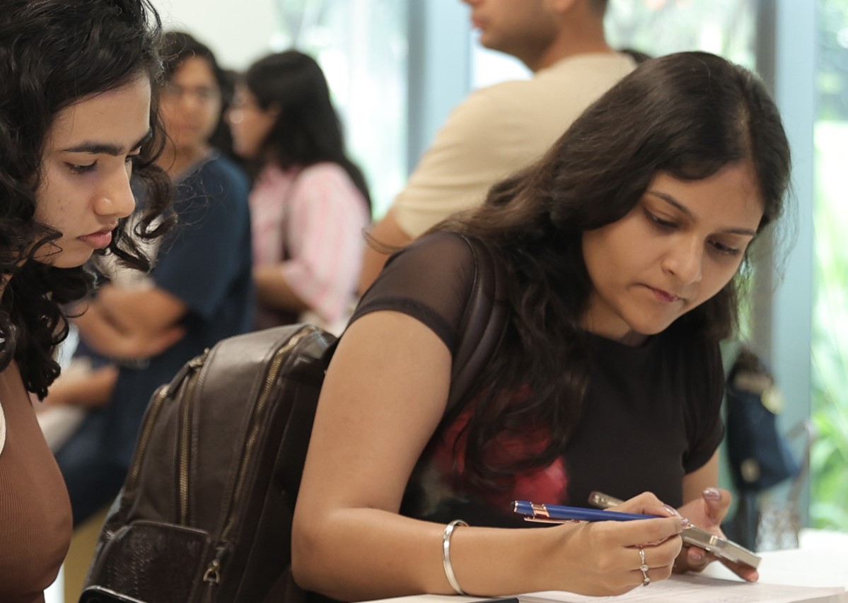 An Economics MSc degree student concentrates on work as they hold a pen